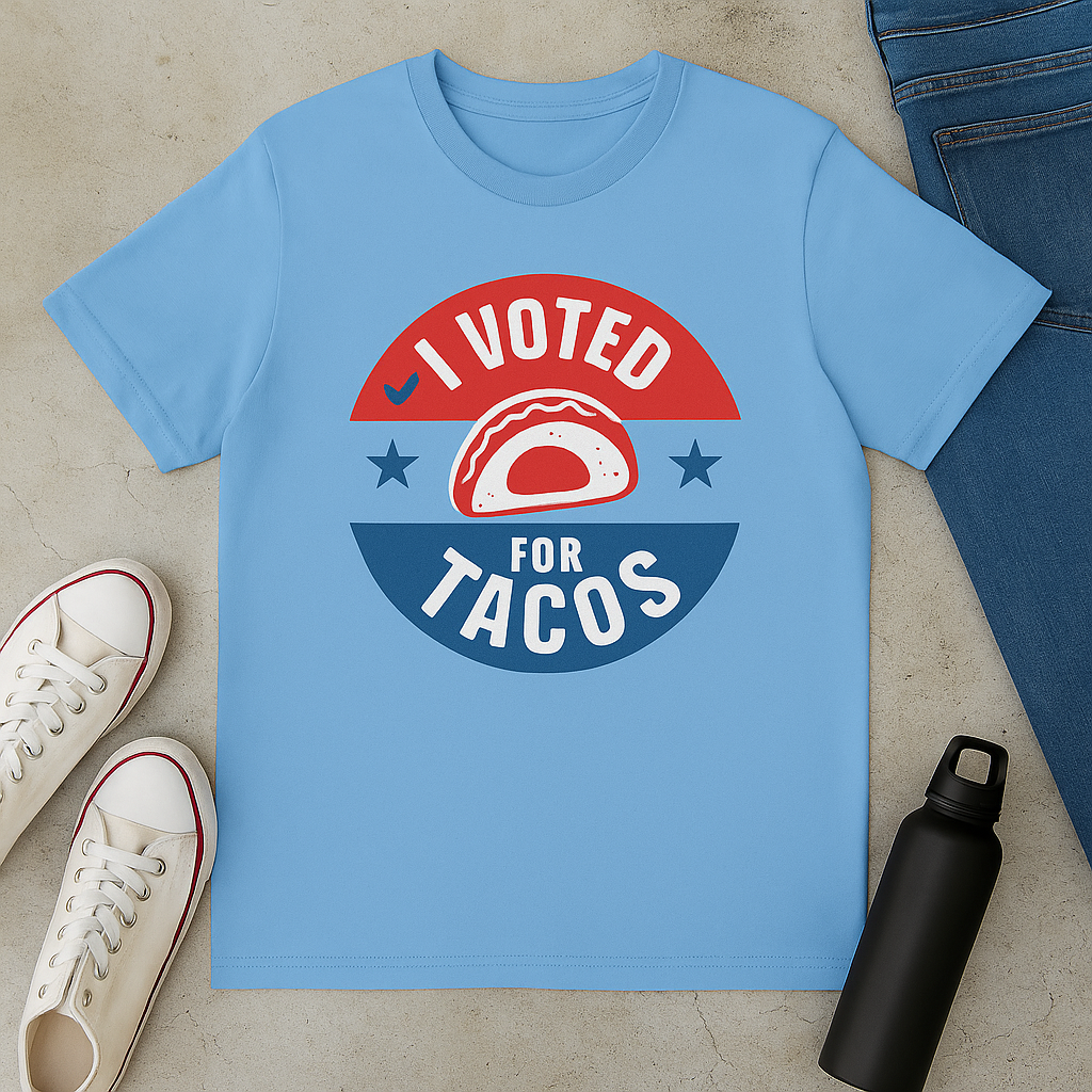 Blue t-shirt with 'I Voted for Tacos' graphic on a concrete surface with shoes and a water bottle.